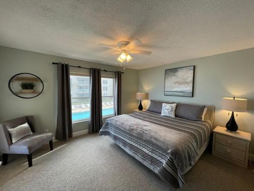 une chambre avec un lit, une chaise et une fenêtre dans l'établissement Refreshing oceanfront gem Remarkable sunrises, à New Smyrna Beach