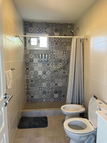 a bathroom with a toilet and a shower at Ecos de mar in Mar del Sur