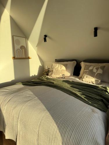 a bedroom with a bed with a green and white comforter at Chill domek in Grzybowo
