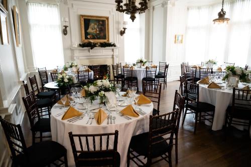 een kamer vol tafels en stoelen met witte tafelkleden bij Mansions on Fifth in Pittsburgh