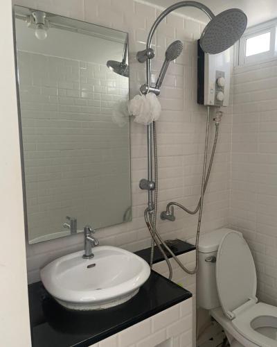 a bathroom with a sink and a shower and a toilet at T-home Maerim in Bān Thung Phuang