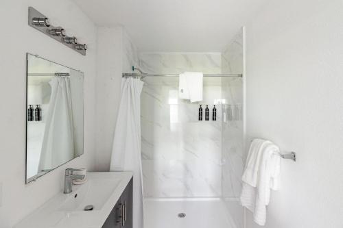 een witte badkamer met douche en wastafel bij Landing Stunning 3BD Pool Gym in Naranja