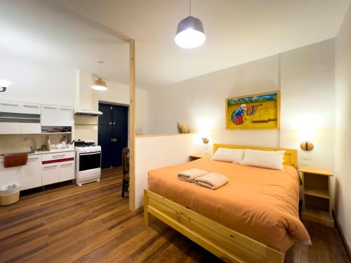 a bedroom with a large bed and a kitchen at Illa B&B in Cusco