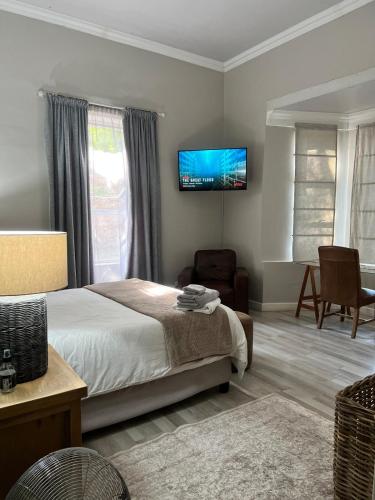 a bedroom with a bed and a tv on the wall at The Townhouse in Piet Retief
