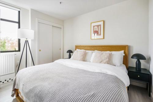 een witte slaapkamer met een groot bed met witte lakens bij Blueground Central Berkeley rooftop nr UC Berkeley SFO-2124 in Berkeley