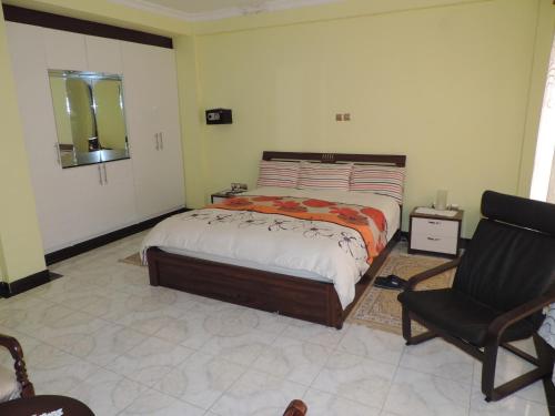 1 dormitorio con 1 cama y 1 silla en Asimba Guest House, en Mekʼelē