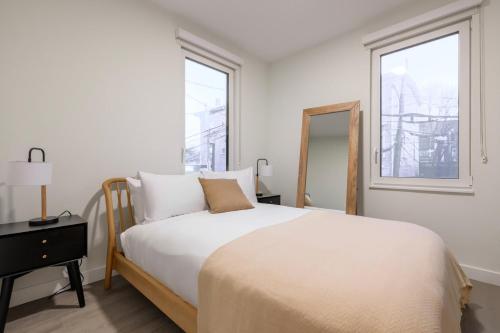 una camera da letto bianca con un letto e una finestra di Blueground Ward Two rooftop nr Prospect Hill BOS-1265 a Somerville