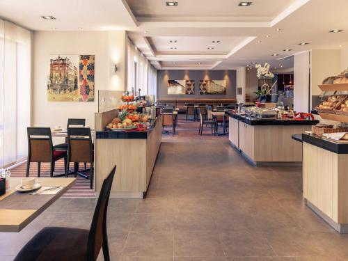 een restaurant met tafels en stoelen en een cafetaria bij Fürther Hotel Mercure Nürnberg West in Fürth