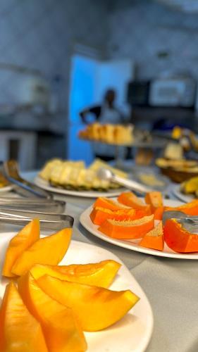 een tafel vol borden met eten en schijfjes sinaasappel erop bij Hotel Monólitos in Quixadá