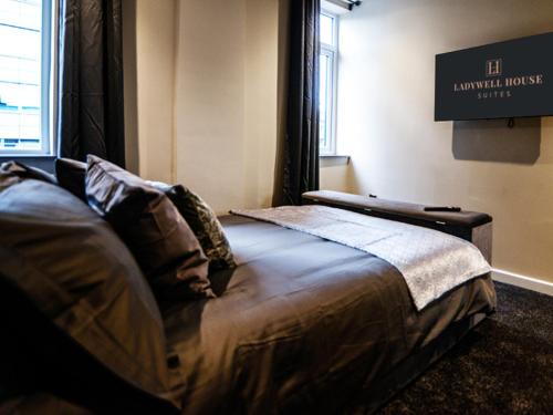 a bedroom with a bed with a sign on the wall at Ladywell House Suites in Birmingham