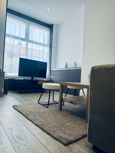 a living room with a table and a tv at Sterling House - by Eazystays in Crewe