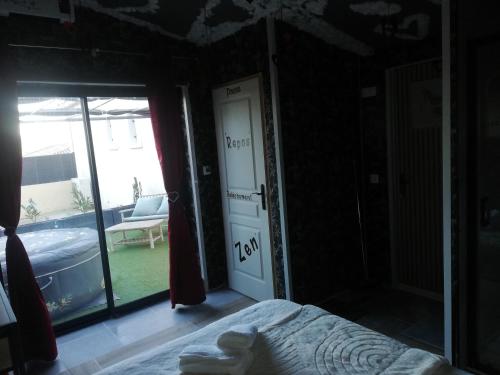 a bedroom with a bed and a door to a yard at Cabalove in Quissac