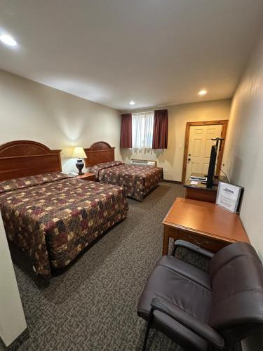 a hotel room with two beds and a couch at The Rushford Inn in Rushford