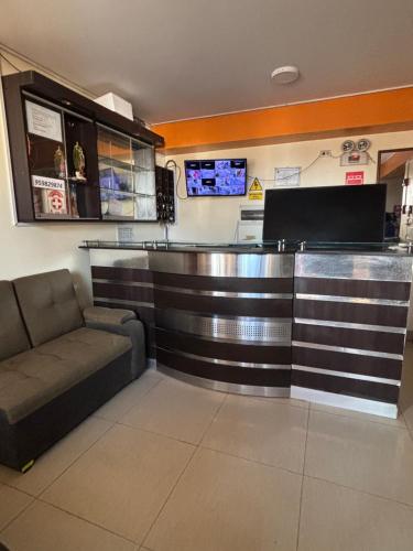 un bar dans un restaurant avec un canapé et un comptoir dans l'établissement Hospedaje Don Luciano, à San Vicente de Cañete