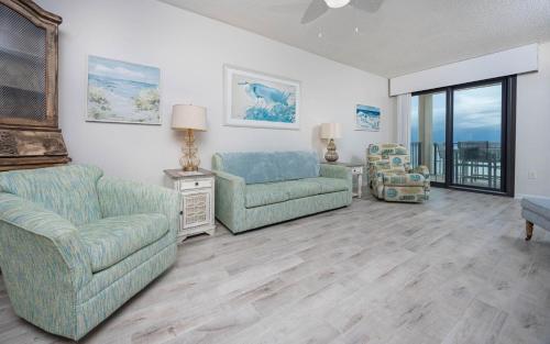 a living room with two chairs and a couch at Phoenix East 1108 in Orange Beach