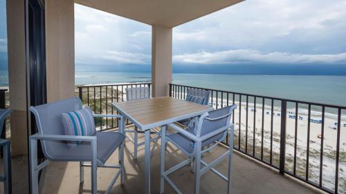 a table and chairs on a balcony with the beach at Phoenix East 1108 in Orange Beach