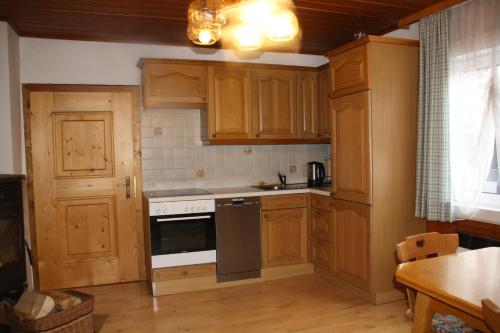 a kitchen with wooden cabinets and a stove top oven at Ferienhaus Feichtn Schuster in Gosau