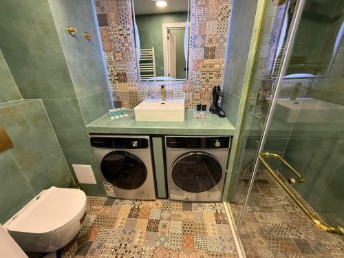 ein Badezimmer mit Toilette, Waschbecken und Waschmaschine in der Unterkunft Luxury Apartments With Mountain View in Neo New Gudauri in Gudauri