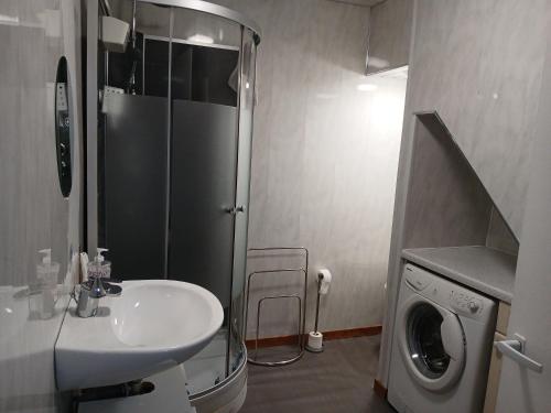 een badkamer met wastafel en wasmachine bij Les 4 Portes in Le Mesnillard