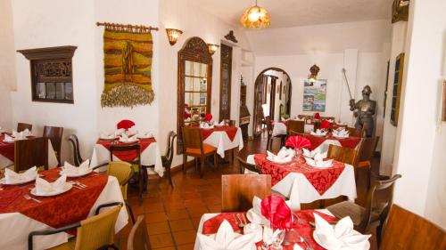 a restaurant with red and white tables and chairs at Hotel Los Frayles in Villa de Leyva