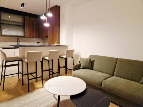 een woonkamer met een bank en een tafel bij Infinity Apartment & Privat Garage in Sarajevo