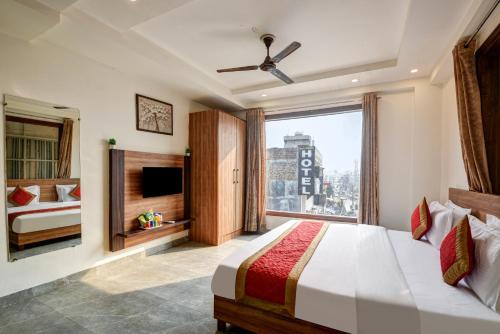 une chambre avec un lit et une grande fenêtre dans l'établissement Hotel Town Stay Near Rajiv Gandhi Cancer Hospital Rohini, à New Delhi