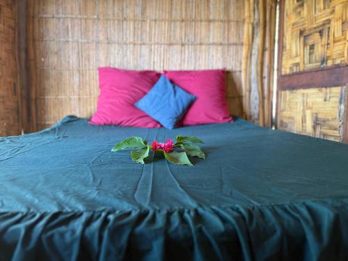a bed with a blue blanket with a flower on it at Fireworks bungalows in White Sands