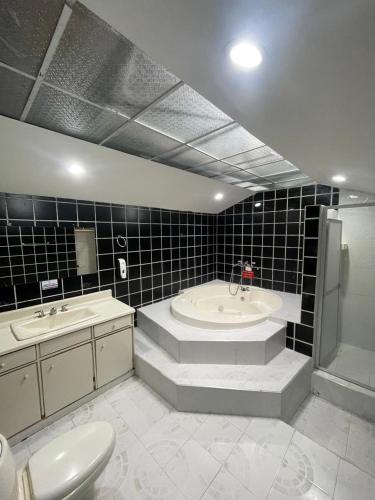 a bathroom with a tub and a sink and a toilet at Hotel Campestre El Cortijo in Santa Rosa de Cabal