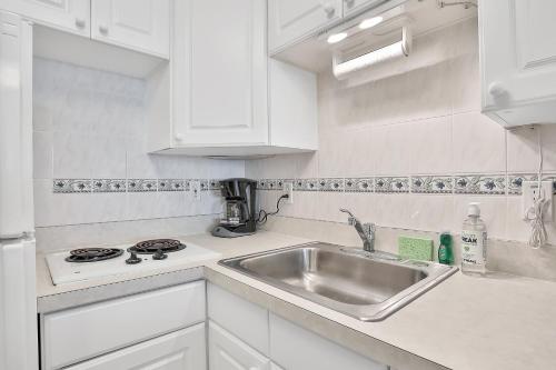 a white kitchen with a sink and a stove at Daytona Beach Resort 532-White Turtle in Daytona Beach