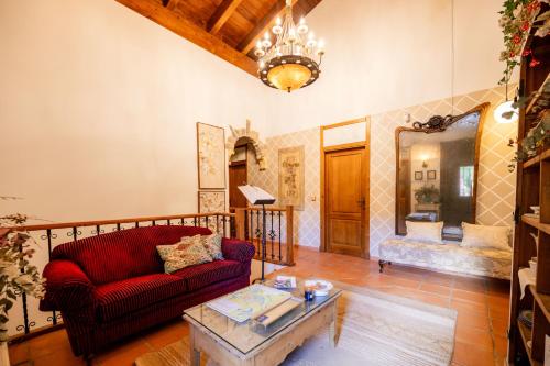 un soggiorno con un divano rosso e un tavolo di Hotel Boutique Barosse Family & Pet Friendly Roo a Jaca