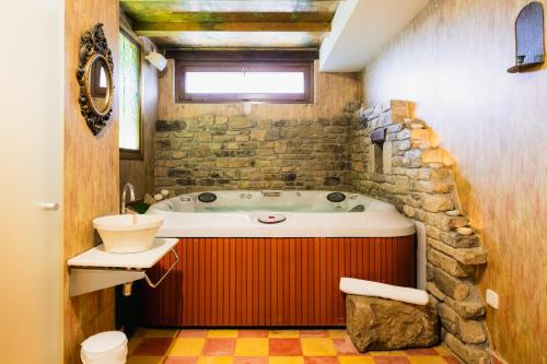 een badkamer met een ligbad en een wastafel bij Hotel Boutique Barosse Family & Pet Friendly Roo in Jaca