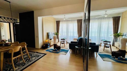 een woonkamer met een bank en een eetkamer bij Mutiara Melaka Beach Resort Condominium,Pantai Puteri Melaka in Melaka