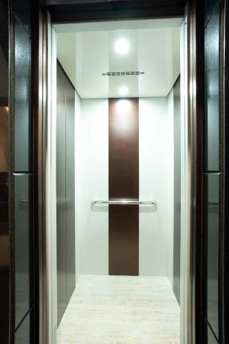 a glass elevator door in a building at Aura Heaven in Thanjāvūr