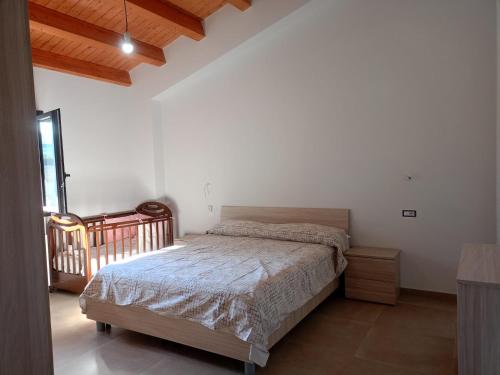 una camera da letto con un letto in una stanza bianca di villa VM a Maniace