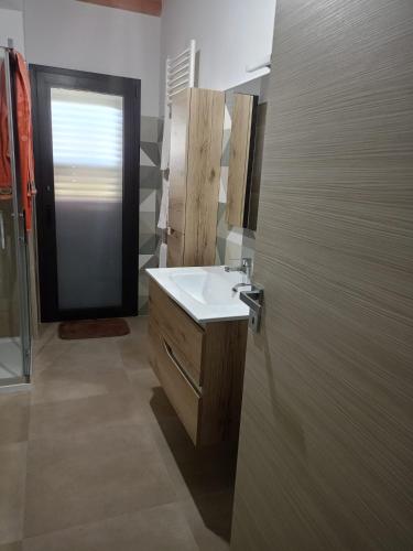 a bathroom with a sink and a mirror and a door at villa VM in Maniace