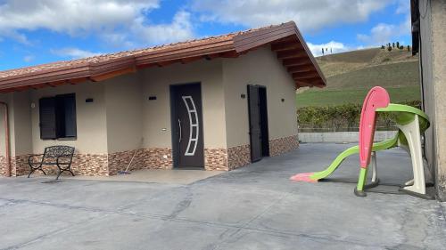 una piccola casa con uno scivolo rosa e verde di villa VM a Maniace