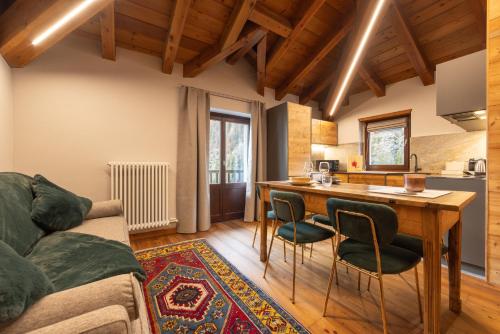 een keuken en woonkamer met een tafel en stoelen bij Maisons Grandes Murailles in Valtournenche