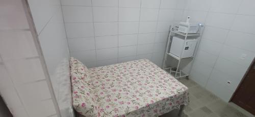 una piccola stanza con una sedia con un tavolo e un microonde di Taberna dos Castilho 1 a Bertioga