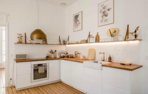 een keuken met witte kasten en een spoelbak bij Splendide Appartement a coté de la Mer Calme 2 Room Wifi Tramway in Nice