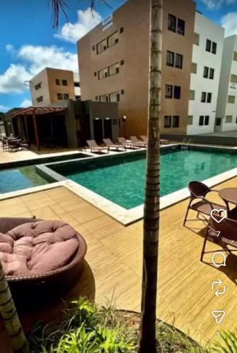 a swimming pool with a bed next to a building at Cantinho do Sossego in João Pessoa