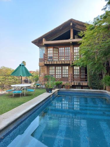 a house with a swimming pool in front of a house at La Casa del Sol - Cuernavaca in Cuernavaca