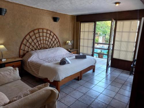 una camera da letto con un letto grande e un divano di La Casa del Sol - Cuernavaca a Cuernavaca