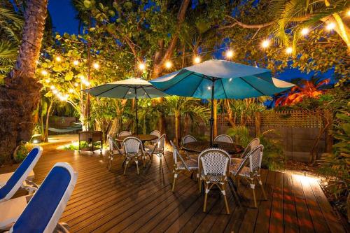 un ponte con sedie, tavoli e ombrelloni di notte di Papa's Hideaway a Key West