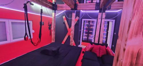 a bedroom with a hanging bed with red walls at Apartman Fantazy spa BDSM in Novi Grad