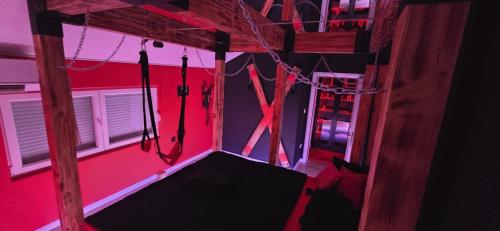 an empty room with a red room with a swing at Apartman Fantazy spa BDSM in Novi Grad