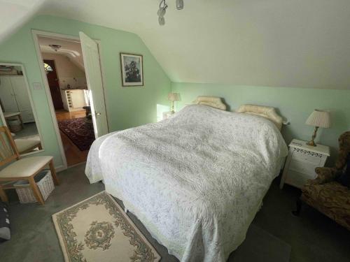 a bedroom with a large bed with a white comforter at Walkers Retreat with garden and views in Holne