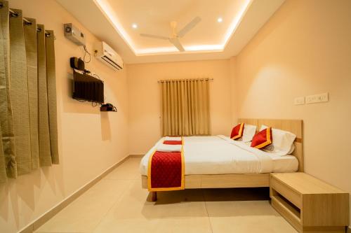 a bedroom with a bed and a ceiling fan at Aura Heaven in Thanjāvūr