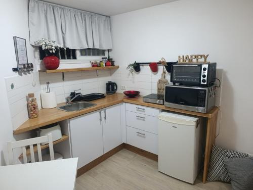 a small kitchen with a sink and a microwave at Hamedina de Silvina in Kafr Sābā