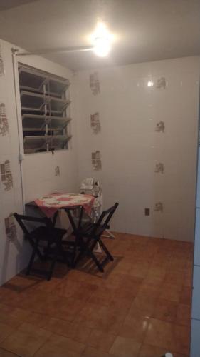 una stanza con un tavolo e delle sedie di casa Magalhães a Laguna