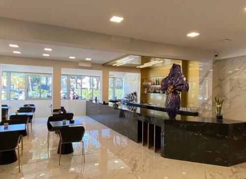 a lobby with a bar with black chairs and tables at B&B Mima Elsa in Milano Marittima